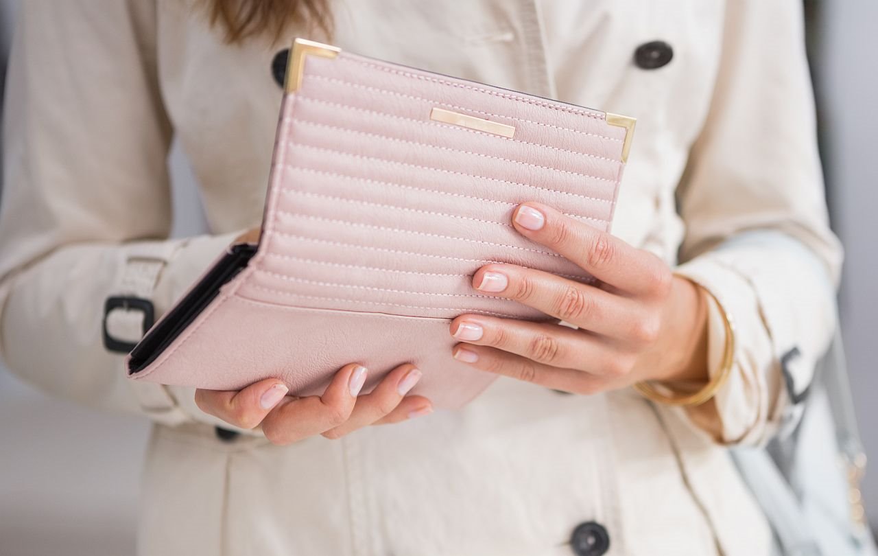 Žena drži roze novčanik