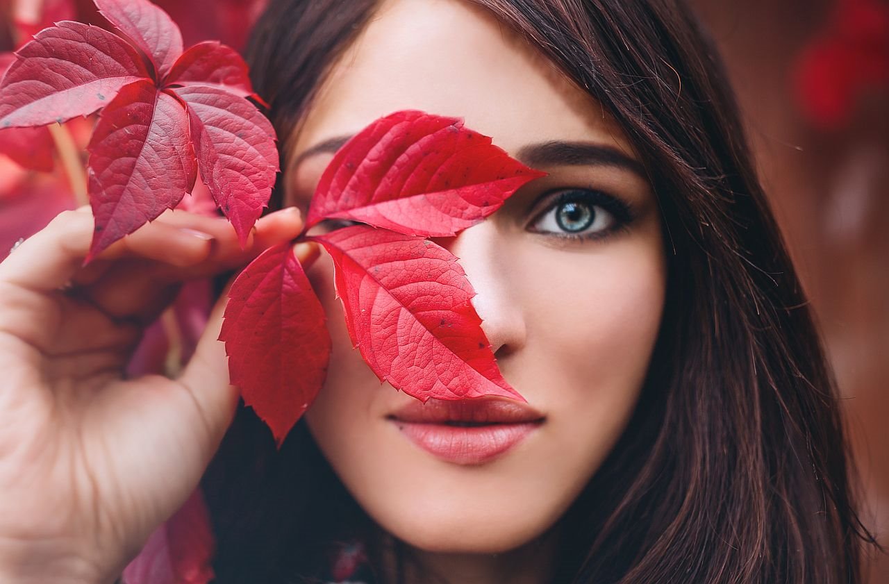 Devojka drži crveni jesenji list