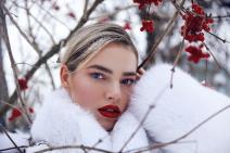 Žena na snegu sa crvenim bobicama