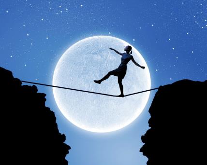 Devojka hoda po konopcu pod svetlošću punog Meseca