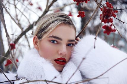 Žena na snegu sa crvenim bobicama