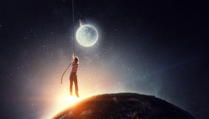 Dečak se užetom drži za pun Mesec koji liči na sijalicu