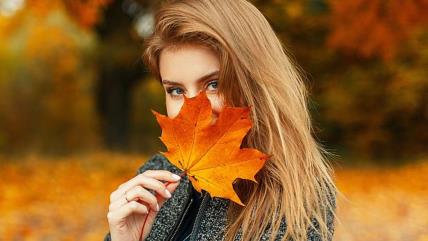 Žena drži opali žuti list