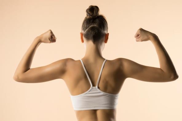 Žena pokazuje zadnje mišiće ruku