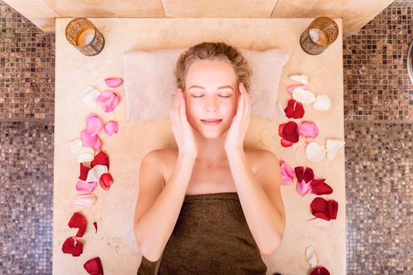 Žena u hamamu sa ružinim laticama