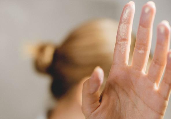 Devojka odmahuje rukom i odbija nešto